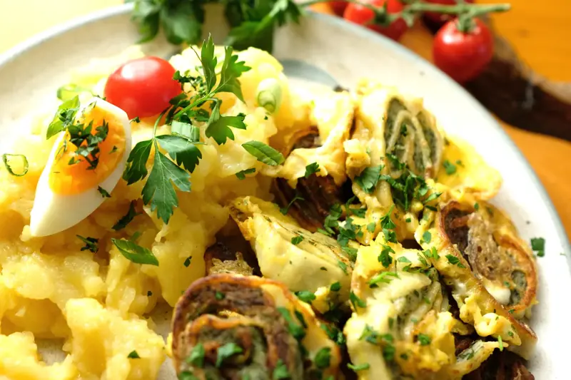 Maultaschen mit Kartoffelsalat auf einem Holzbrett